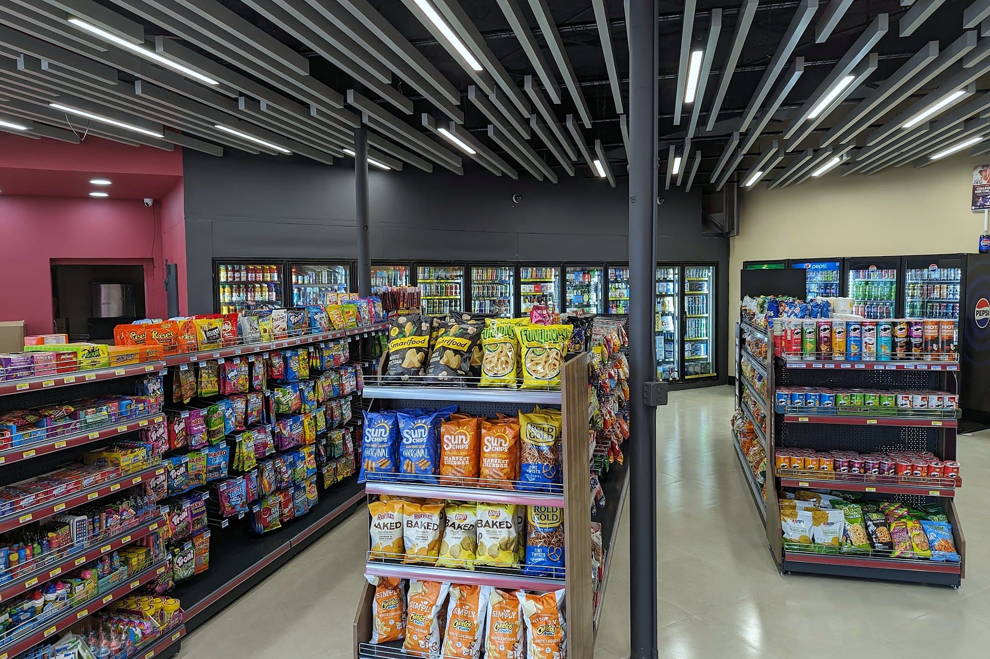 Inside Skyline Express: bright aisles of candy and chips under a slatted ceiling, cold-drink coolers along the back wall